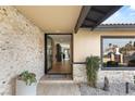 Inviting home entrance featuring stone accents, a stylish front door, and desert landscaping at 6975 Darby Ave, Las Vegas, NV 89117