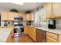 Bright kitchen featuring stainless steel appliances, granite countertops and wood flooring at 7317 Bosky Springs St, Las Vegas, NV 89131