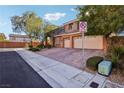 Two-story home boasting a tile roof, a two-car garage and low maintenance desert landscaping at 8001 Pavarotti Ave, Las Vegas, NV 89178