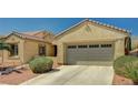 Inviting single-story home with a two-car garage and desert landscaping under a clear blue sky at 8129 Jim Steele Falls St, North Las Vegas, NV 89085