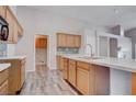 Bright kitchen boasts wood cabinets, modern countertops, stylish backsplash, and wood-look flooring at 1036 Kennebunk Cir, Henderson, NV 89015