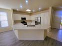 Well-lit kitchen features stainless steel appliances, white cabinetry and an eat in bar at 10580 Riva Grande Ct, Las Vegas, NV 89135