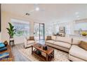 Bright living room features a neutral color palette, stylish furniture, and access to the outdoors at 10580 Riva Grande Ct, Las Vegas, NV 89135
