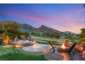 Scenic backyard with a cozy fire pit and elegant outdoor seating area, surrounded by lush landscaping at 11680 Evergreen Creek Ln, Las Vegas, NV 89135