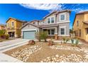 Charming two-story home with a grey exterior, stone accents, a blue-grey garage door, and low-maintenance desert landscaping at 140 Rolling Cove Ave, Henderson, NV 89011