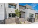Contemporary stucco townhome with gated entry and a small tree in the front yard at 1452 Melodic Lark Ln, Las Vegas, NV 89138