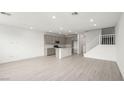 Open-concept living area featuring tile floors, a kitchen island, and a staircase at 1452 Melodic Lark Ln, Las Vegas, NV 89138