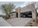 Attractive stucco home with a two-car garage, desert landscaping, and a brick-paved driveway at 1608 Rock Ridge Pl, North Las Vegas, NV 89084