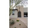 Inviting home exterior with an arched front door, desert landscaping, and a brick-paved driveway at 1608 Rock Ridge Pl, North Las Vegas, NV 89084