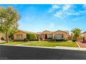 Charming single-story home featuring a well-manicured lawn, desert landscaping and beautiful architecture at 215 Great Gable Dr, Las Vegas, NV 89183