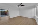 Bright living room featuring modern ceiling fan, wood-look floors, and sliding doors to the backyard at 241 E Van Wagenen St, Henderson, NV 89015