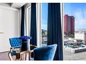 Chic sitting area with blue velvet chairs offers a view of the Las Vegas skyline at 2700 Las Vegas Blvd # 1401, Las Vegas, NV 89109