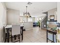 Bright dining area with tile floors, modern light fixture, and views into the living room at 3023 Sunrise Bay Ave, North Las Vegas, NV 89031