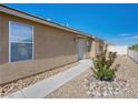 Tan house with desert landscaping, concrete walkway, and a white security door at 4016 Balsam Mountain St, Las Vegas, NV 89129