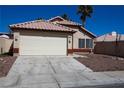 Inviting front exterior featuring a two-car garage and desert landscaping for easy upkeep at 5200 Brookmere Dr, Las Vegas, NV 89130