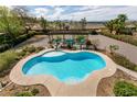 An aerial view of the Kidney-shaped pool, complete with lounge area, set amongst desert landscaping at 6915 Cedar Basin Ave, Las Vegas, NV 89142