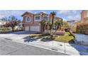 Charming home with a three-car garage, arched windows, and desert landscaping in the front yard at 7425 Enchanted Hills Ct, Las Vegas, NV 89129