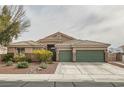 Single-story home featuring a three-car garage, desert landscaping, and tile roof at 7690 Blue Whirlpool St, Las Vegas, NV 89131