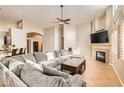 Open-concept living room with tile flooring, a fireplace, and a ceiling fan at 7690 Blue Whirlpool St, Las Vegas, NV 89131