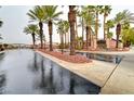 Gated community entrance with lush palm trees and well-maintained landscaping at 9677 Emeraude Ave, Las Vegas, NV 89147