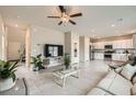 Open-concept living room with modern tile flooring leading into a bright kitchen with stainless steel appliances at 4454 Lantern Point Ave, North Las Vegas, NV 89084