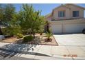 Inviting front yard with mature trees, a well-maintained lawn, and a spacious driveway leading to the garage at 10417 Niagara Falls Ln, Las Vegas, NV 89144