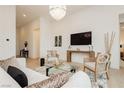 A living room area featuring a white sofa, plush pillows, a modern glass table, and an entertainment center at 11700 Belorado Ave, Las Vegas, NV 89138