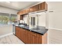 Galley kitchen featuring dark counters, updated cabinets, stainless steel dishwasher and an open view of living area at 1405 Vegas Valley Dr # 226, Las Vegas, NV 89169