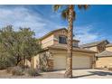Attractive two-story home with a beige exterior, a palm tree, and a three-car garage at 1684 Flores Ln, Henderson, NV 89012