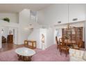 Open-concept dining area with elegant chandelier, pink carpet, and lots of natural light at 1813 Villa Vista Way, Las Vegas, NV 89128