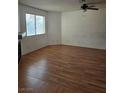 A view of an empty living room featuring laminate flooring, a ceiling fan, and a fireplace at 2232 Aspen Mirror Way # 204, Laughlin, NV 89029