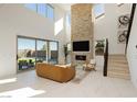 Spacious living area with a stone fireplace, large windows, and a sliding door leading to the outdoor area at 350 Gandara St, Las Vegas, NV 89138