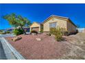 Single-story home boasts desert landscaping, a quaint front yard, and a two-car garage at 3854 E Chaffe Ave, Pahrump, NV 89061