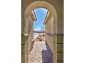 Arched entry to home shows brick pavers and desert landscaping at 4680 Suntree Ct, Pahrump, NV 89061