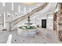 Grand foyer with high ceilings, elegant staircase, stone accents, a fountain, and unique tile flooring at 503 Aaron Way, Boulder City, NV 89005