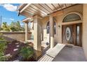 Inviting front entrance with decorative wood door, arched window and covered porch at 5690 N Park St, Las Vegas, NV 89149