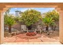Cozy outdoor fire pit with seating area and mature landscaping, perfect for gatherings at 6405 Break Point Ave, Las Vegas, NV 89130