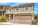 Two-story home with a beige facade, a two-car garage, and a brick driveway at 6484 Mount Eden Ave, Las Vegas, NV 89139