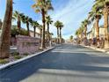 Gated community entrance with lush landscaping and mature palm trees, welcoming you home at 6625 Gossamer Fog Ave, Las Vegas, NV 89139