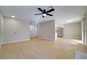 Spacious living room featuring ceiling fan, wood floors, and access to kitchen area at 6649 W Tropicana Ave # 101, Las Vegas, NV 89103