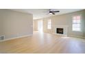 Bright living room with modern ceiling fan, fireplace, and light wood flooring at 6649 W Tropicana Ave # 101, Las Vegas, NV 89103