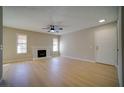 Cozy living room enhanced by natural light, a traditional fireplace, and sleek wood-style flooring at 6649 W Tropicana Ave # 101, Las Vegas, NV 89103