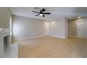 Spacious living area featuring wood-style floors, neutral walls, and a classic white-brick fireplace at 6649 W Tropicana Ave # 101, Las Vegas, NV 89103