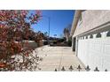 The three car garage with a long driveway and wrought iron fence and gate at 8216 Gillette St, Las Vegas, NV 89117