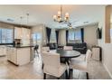 Open living space with a large dining table, ceiling fan, and comfortable couches at 8490 Classique Ave # 101, Las Vegas, NV 89178