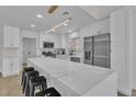 Modern kitchen featuring white cabinets, stainless steel appliances, and a large marble island with bar stools at 8812 Stoney Point Dr, Las Vegas, NV 89134