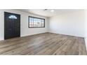 Bright living room featuring wood-look floors, large windows, and a modern front door at 887 W Carey Ave, North Las Vegas, NV 89030