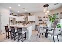 Bright kitchen featuring a central island, stainless appliances, and a dining area with a glass table at 10847 Intro Ave, Las Vegas, NV 89135