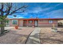 Single story home with rock landscaping, mature trees, and a curved sidewalk at 1113 Date St, Las Vegas, NV 89108