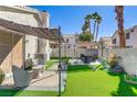 Lush backyard featuring artificial grass, lounge furniture, and a shaded pergola for outdoor relaxation at 139 Serenade Ct, Henderson, NV 89074